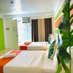 A hotel room with two beds, a window with curtains, an air conditioning unit, and a green plant. - Islands Stay Hotel Mactan (Lapu-Lapu)