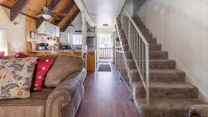 A cozy living room with a brown leather couch, a wooden ceiling, and a staircase leading to an upper level. - Mammoth View Villas 20-Nice townhome close to the Village (Mammoth Lakes)