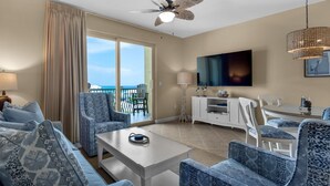 A modern hotel room with a balcony, a flat-screen TV, and a ceiling fan. - Balcony Views of the Gulf, Zero-Entry Pool, Free Beach Chair Service (Miramar Beach)