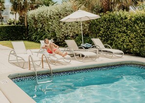 A poolside area with lounge chairs and a pool. - Beach Haus Bal Harbour (Bal Harbour)
