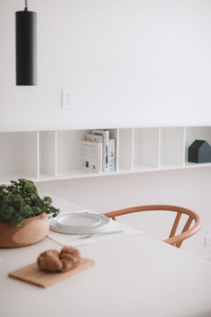 A white dining table with a plate, a bowl, and a plant. - Beach Haus Bal Harbour (Bal Harbour)