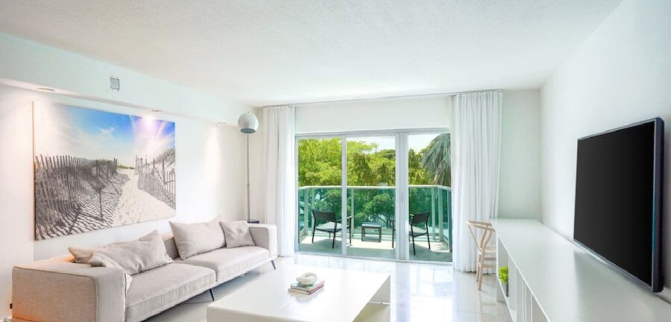 Uma sala de estar moderna com um sofá, mesa de centro e televisão de tela plana.