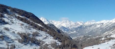 A snowy mountain landscape with a clear blue sky.