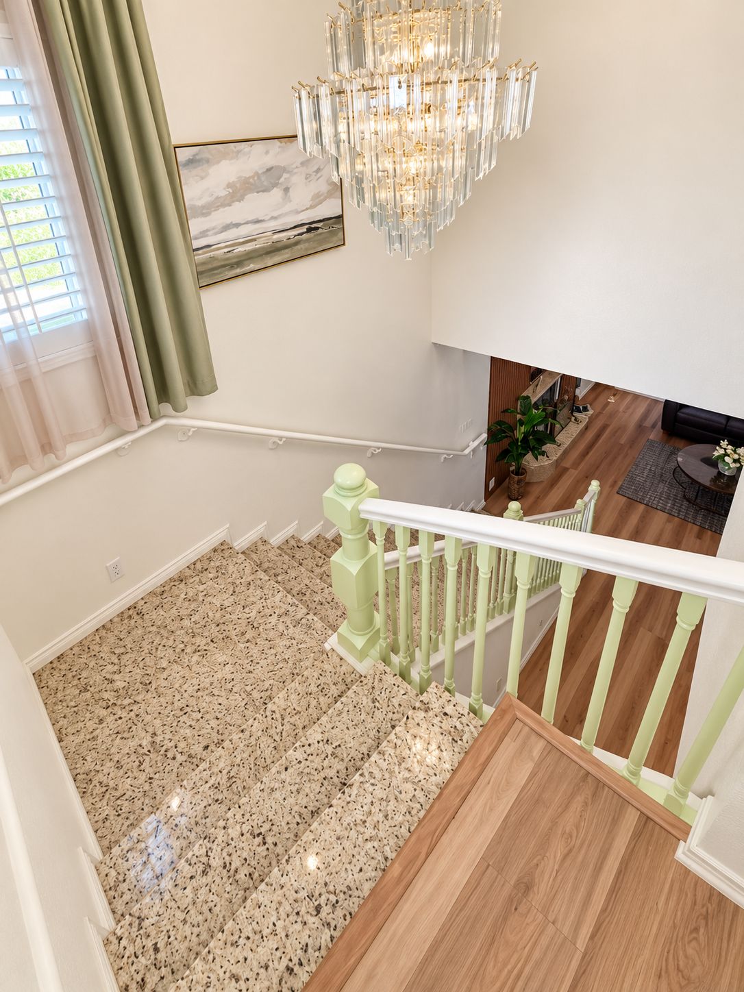 A staircase with a light green railing leading to a second floor.
