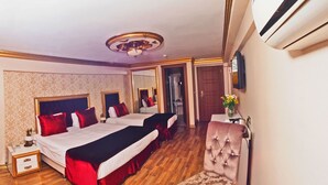 A hotel room with two beds, a chair, a small table, and a mirror. - Marmara Deluxe Hotel (Istanbul)