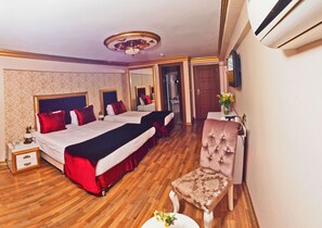 Une chambre d’hôtel avec deux lits, une chaise, une petite table et un miroir.