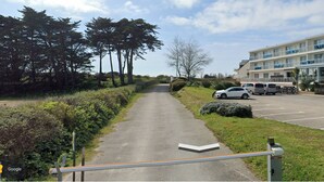 A pathway leading to a building with a parking area and a row of trees. - Spacious, bright apartment close to the bay's beaches (Quiberon)