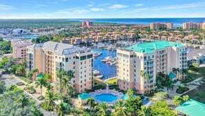 Un complexe hôtelier comprenant plusieurs bâtiments, un port de plaisance et une piscine.