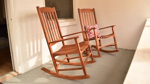 Two wooden rocking chairs with a white brick wall and a window in the background. - 3bd, 1ba across from Pocosin Lakes Wildlife Refuge (Pantego)