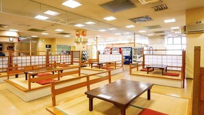 Una habitación japonesa tradicional con esteras de tatami, muebles de madera y una máquina expendedora.