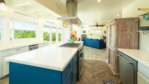 A spacious kitchen with a large island, white cabinetry, and a blue accent wall. - Private Paradise, Waterfront Home - 15 minutes from Key West (Key West)
