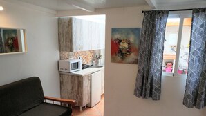 A compact living space with a sofa, a kitchenette, and a dining area.