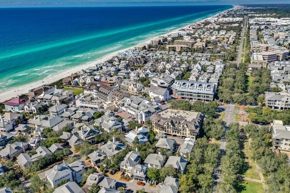 A coastal residential area with houses, a beach, and a road.