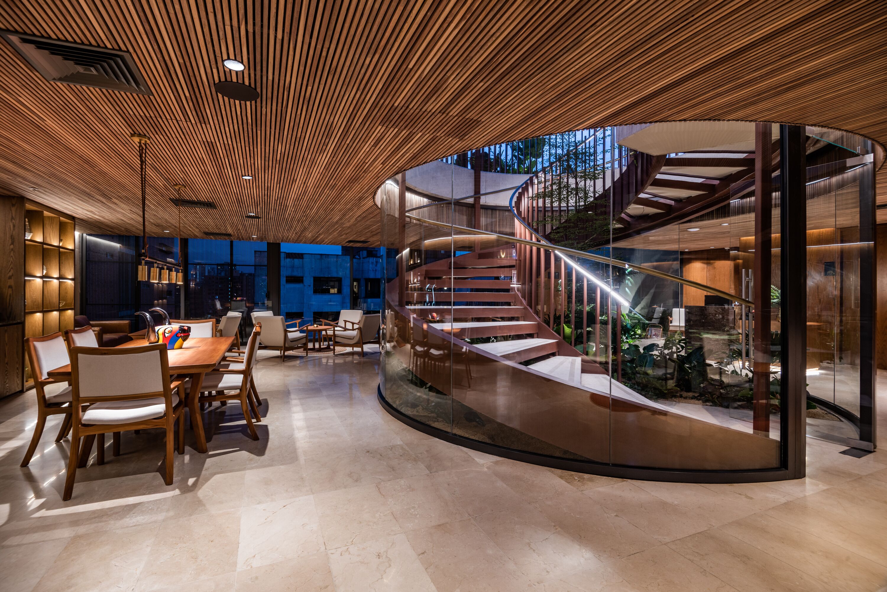 A modern interior with a curved staircase, wooden ceiling, and a dining area with chairs and a table.