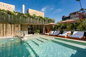 Una piscina al aire libre, sillones reclinables de piscina