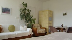 A hotel room with two beds, a sofa, a chair, a small table, and a potted plant. - Ferienwohnung A3 - One Bedroom Apartment, Sleeps 3 (Klocksin)