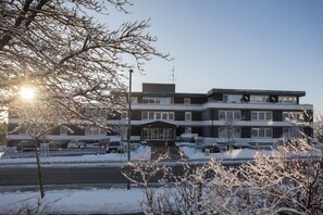 Ein mehrstöckiges Gebäude mit modernem architektonischen Design, mit flachem Dach und großen Fenstern.