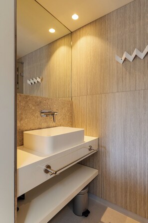 Un bagno moderno con lavabo incassato, mobile vanità e cestino.