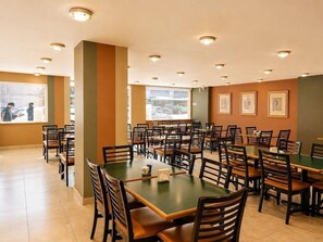 A spacious dining area with multiple tables and chairs, large windows with blinds, and framed pictures on the walls. - Hotel Son Mar Monterrey Centro (Monterrey)