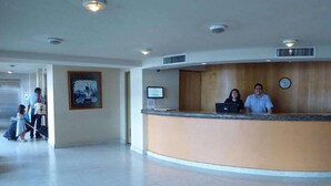 A reception area with a curved counter, a clock, and a framed picture on the wall. - Hotel Son Mar Monterrey Centro (Monterrey)