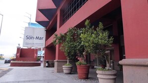 A hotel with a red facade, outdoor seating area, and potted plants. - Hotel Son Mar Monterrey Centro (Monterrey)