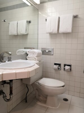 A bathroom with a sink, toilet, and two towel racks. - Hotel Son Mar Monterrey Centro (Monterrey)