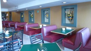A restaurant interior with booths and tables, some with floral centerpieces. - Hotel Son Mar Monterrey Centro (Monterrey)
