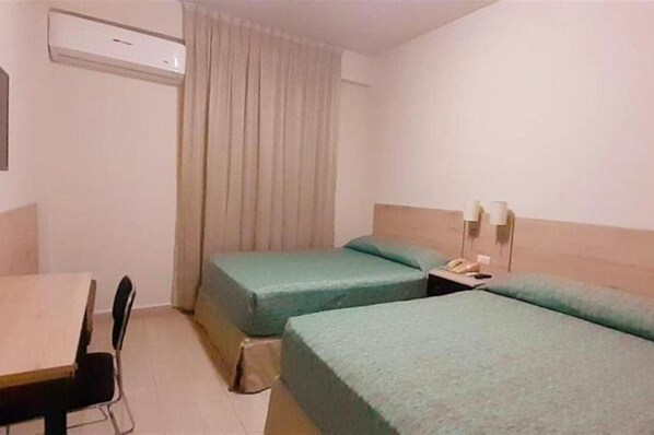 A hotel room with two single beds, a small table, a chair, and an air conditioning unit. - Hotel Son Mar Monterrey Centro (Monterrey)