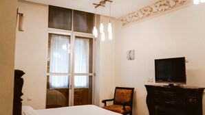 Une chambre d’hôtel équipée d’un lit, d’une télévision, d’une chaise et d’une cheminée.