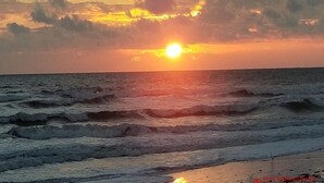 A sunset over the ocean with waves.