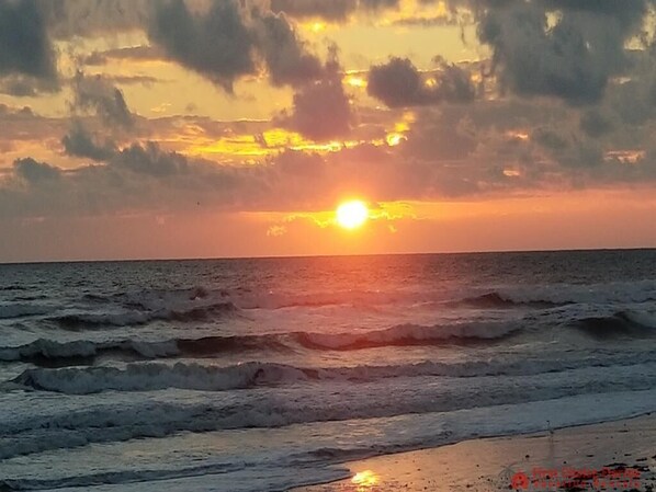 A sunset over the ocean with waves.