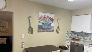 Une cuisine compacte comprenant une table à manger, des chaises, un lave-vaisselle et un évier.