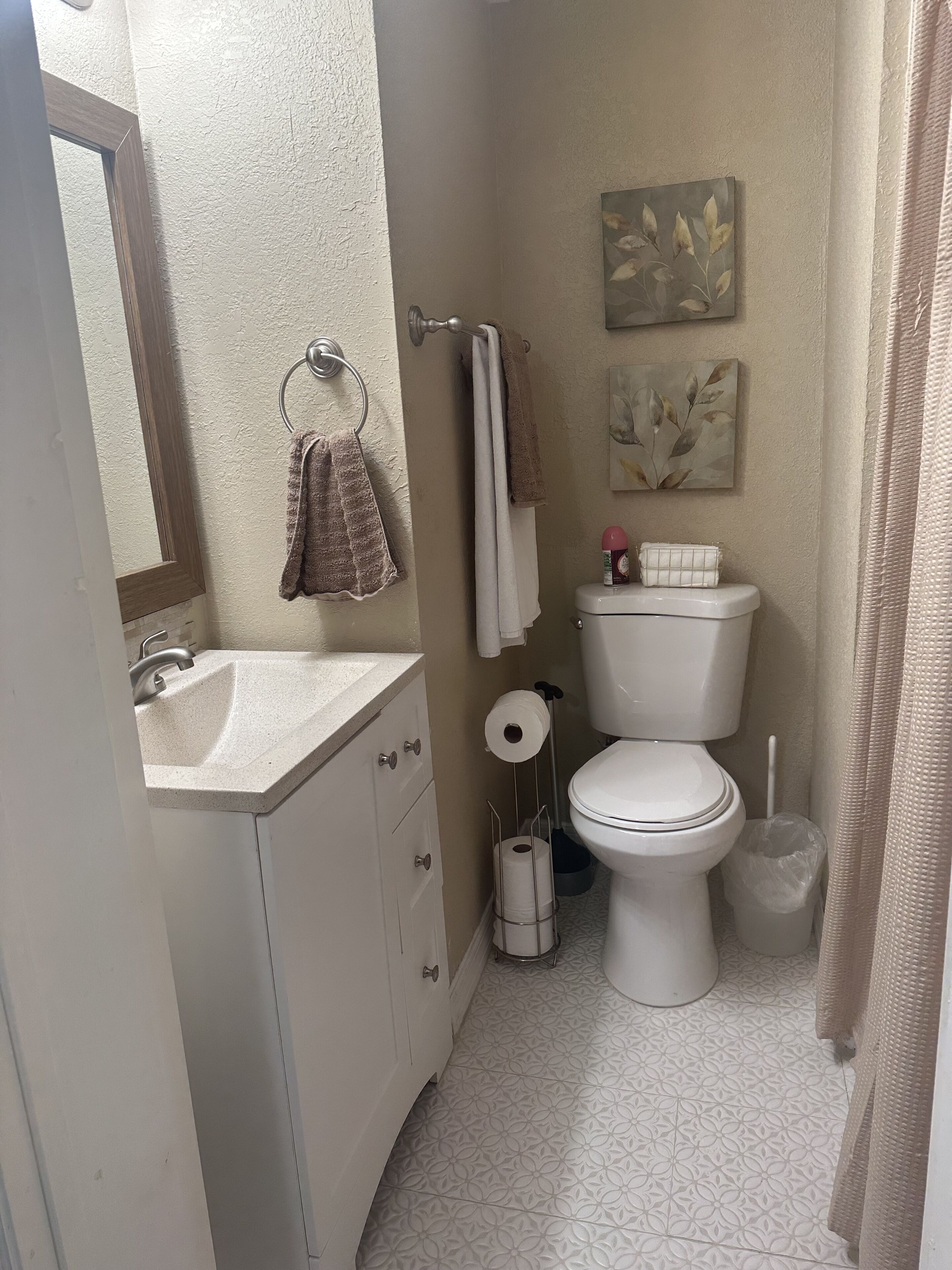 Une salle de bain équipée d’un lavabo, de toilettes et d’un rideau de douche.