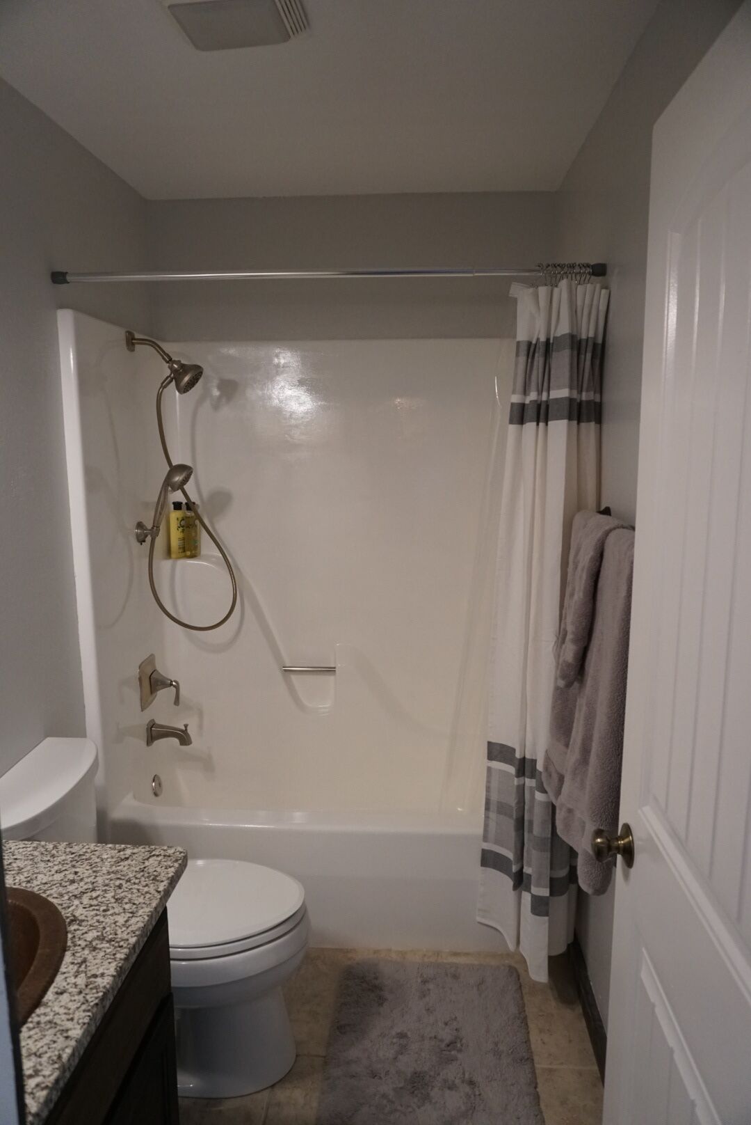 A bathroom with a shower, toilet, and sink.