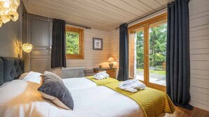 Un dormitorio con una cama grande, dos mesitas de noche, un escritorio y una ventana con cortinas.