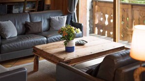 Una sala de estar acogedora con un sofá de cuero, una mesa de centro de madera y una planta en maceta.
