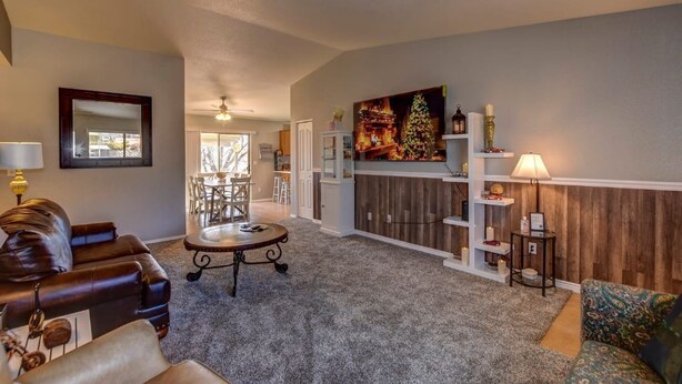 A spacious living room with a leather sofa, a round coffee table, and a dining area in the background. - This One's Better-More To Do-More Modern-More Fun!!! (Prescott Valley)