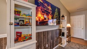 A room with a popcorn cabinet, a fireplace with a Christmas tree, and a lamp on a shelf. - This One's Better-More To Do-More Modern-More Fun!!! (Prescott Valley)