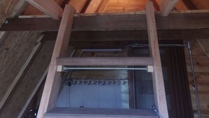 Un grenier en bois avec des poutres apparentes et une lucarne.