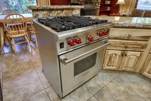 A kitchen with a stainless steel stove, wooden cabinets, and a tiled floor. - (52) Tuolumne Meadow (1 Bedroom Only) at The Redwoods In Yosemite (Yosemite National Park)