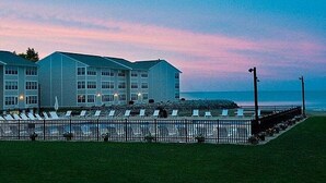 Un hôtel à étages, doté d’une piscine et de chaises longues, et offrant une vue sur l’océan.