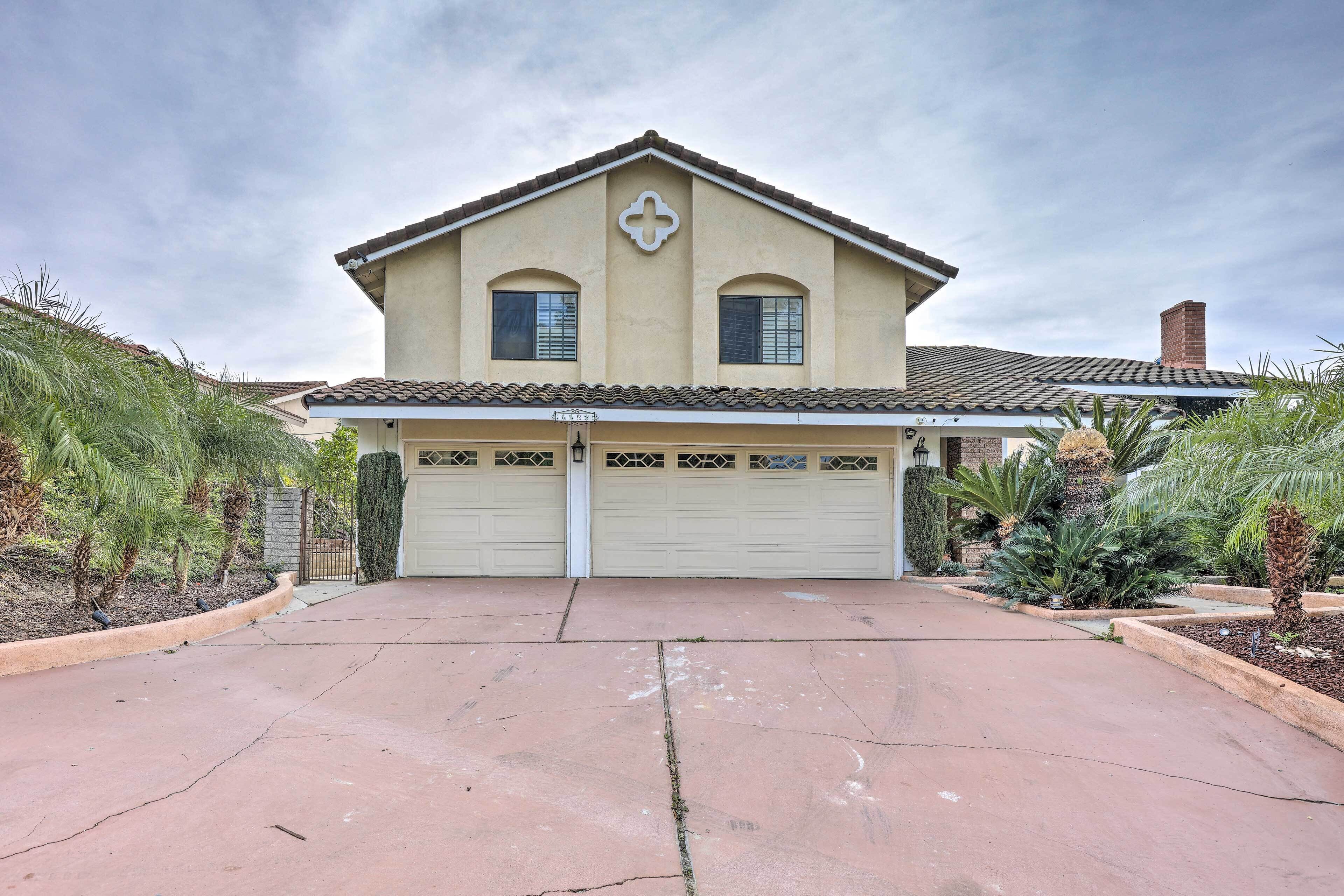 A two-story house with a garage, a cross-shaped window, and a tiled roof.