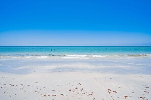Una playa con aguas azules cristalinas y arena blanca.