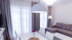 Ett modernt vardagsrum med ett vitt bord, en soffa och en lampa.