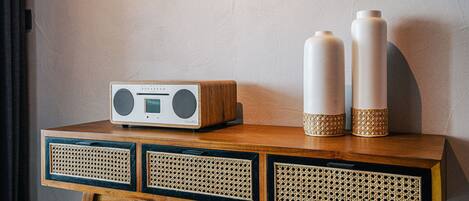 A wooden table with a radio, two vases, and three drawers.