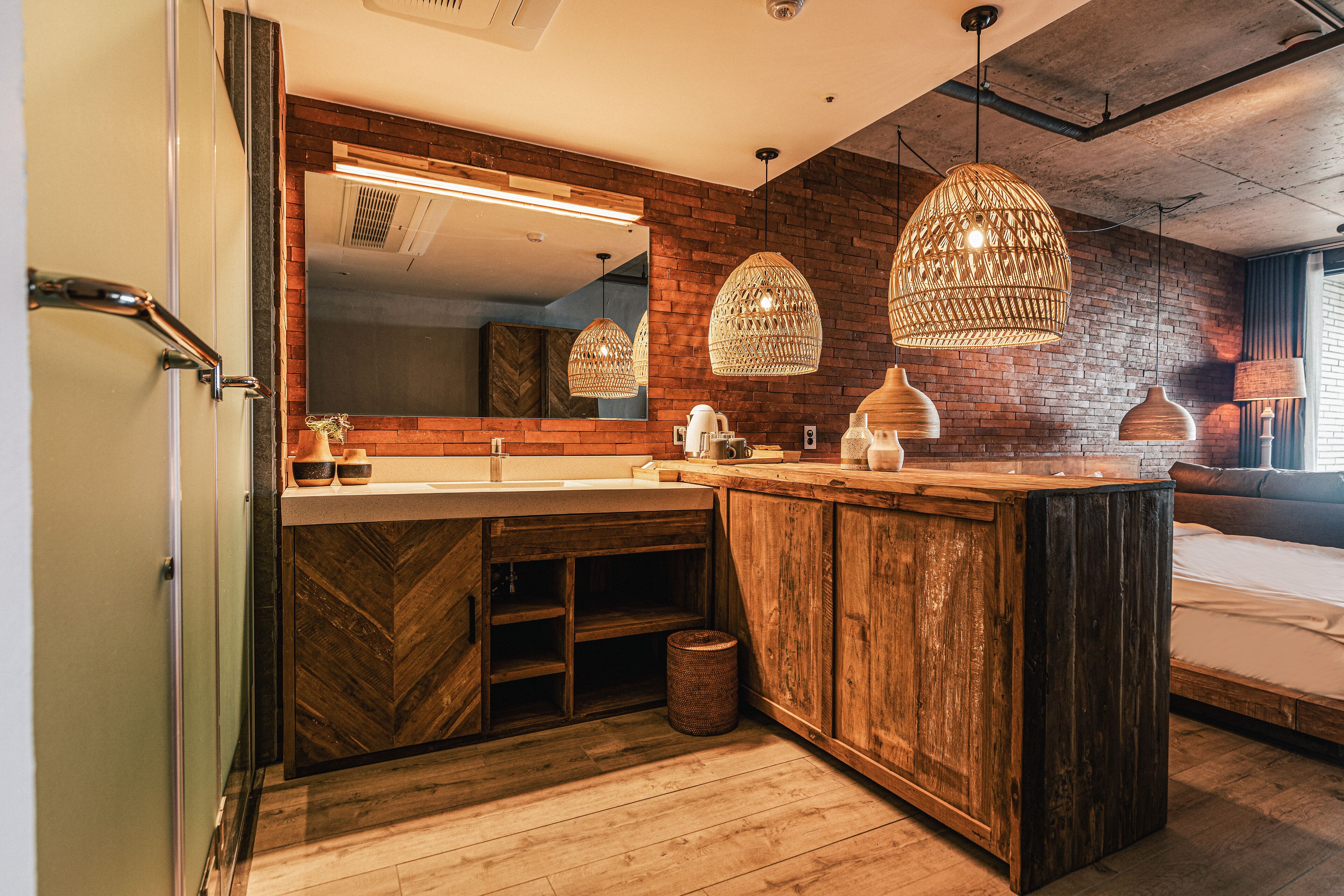 A modern bathroom with a wooden vanity, a large mirror, and pendant lights.