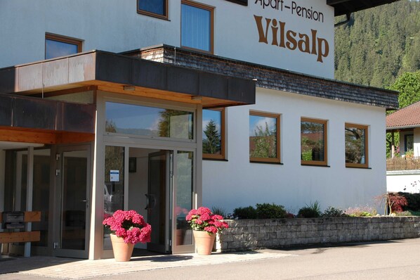 A building with a sign reading 'Apart-Pension Wilsalp' and a covered entrance.