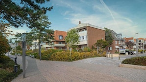 Área residencial com edifícios de tijolo, caminhos pavimentados e áreas verdes.