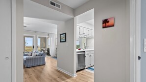 A modern living room with a sofa and a dining area with cabinets and a kitchen counter. - Roomy & Spacious Villa with Great Marsh Views! (Seabrook Island)