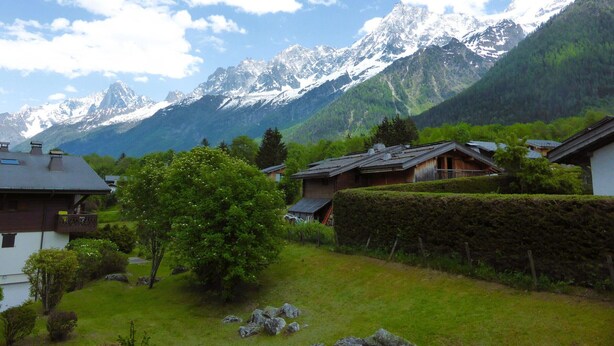 A mountain village with traditional houses, a well-maintained garden, and a backdrop of snow-capped peaks. - 2-room cabin apartment in Les Houches, balcony, sleeps 4 (Les Houches)
